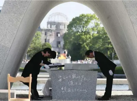  ?? AFP/GETTY IMAGES ?? Hiroshima Mayor Kazumi Matsui, right, offers a list of people who have died in the last year from the side effects of radiation from the 1945 bombing.