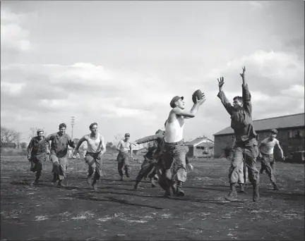  ?? CHARLES GORRY — THE ASSOCIATED PRESS ?? Sgt. Armand Levy snags a pass as Pfc. James Vick converges for the tackle during a pickup football game in Japan on Nov. 9, 1945.