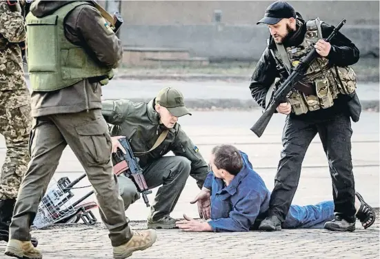 ?? HANDL SENNA / AFP ?? Un grup de soldats ucraïnesos en un control després d’un bombardeig a la ciutat de Khàrkiv
