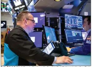  ?? (AP/New York Stock Exchange/David L. Nemec) ?? Trader Robert Arciero (left) works Monday on the New York Stock Exchange trading floor. Stocks fell in afternoon trading on Wall Street as the market extended losses from last week.