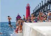  ?? Cory Morse / Associated Press ?? Beachgoers fill Grand Haven State Park and City Beach on July 7 in Michigan, which has been in a 90-degree plus heat wave for several days.