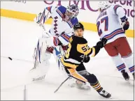  ?? Gene J. Puskar / Associated Press ?? Rangers goaltender Igor Shesterkin, left, clears the puck in front of the Penguins’ Teddy Blueger (53) on Friday.