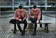  ?? ANDRES KUDACKI — THE ASSOCIATED PRESS FILE ?? Two men check their phones April 8 as they sit near the harbor in Stockholm, Sweden.