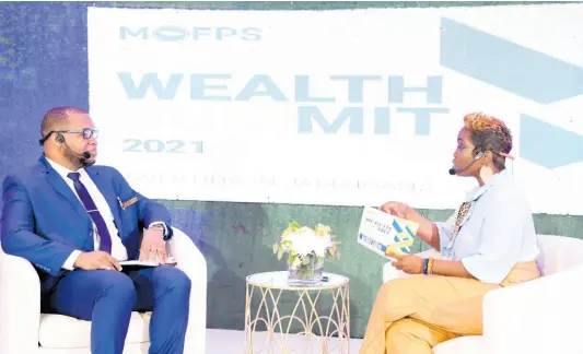  ?? ?? Sheldon Christian (left) dialogues with host of the 2021 Wealth Summit held by the Ministry of Finance and Public Service.