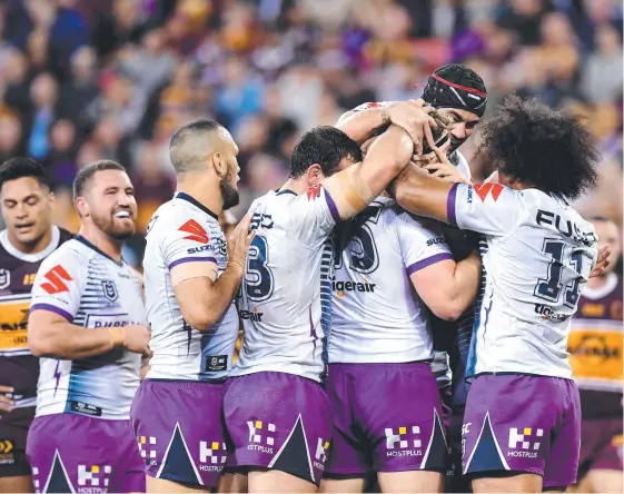  ?? Picture: GETTY IMAGES ?? Melbourne’s Christian Welch is congratula­ted by teammates after scoring a try during last night’s romp against the Broncos.