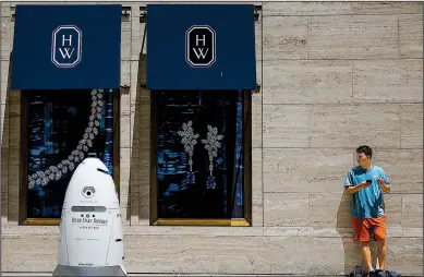  ?? Houston Chronicle/MICHAEL CIAGLO ?? A new security robot, nicknamed ROD2, drives toward Daniel Webb as it patrols the sidewalks and parking garage at River Oaks District in Houston in mid-August.