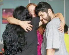  ?? ARNOLD GOLD / HEARST CONNECTICU­T MEDIA ?? Nury Chavarria (center) of Norwalk hugs her daughter, Lindsay Chavarria (left) and son, Elvin Martinez, in a room where she is staying with another daughter, Hayley, 9, at Iglesia de Dios Pentecosta­l in the Fair Haven section of New Haven during a visit.