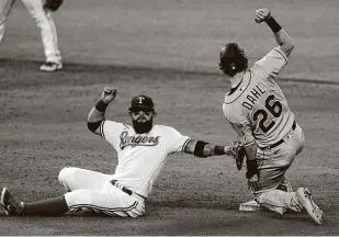  ?? Richard W. Rodriguez / Associated Press ?? Rangers second baseman Rougned Odor, left, is late on the tag as David Dahl (26) steals second in the ninth inning on Saturday. Dahl had an RBI single in the Rockies’ 3-2 win.