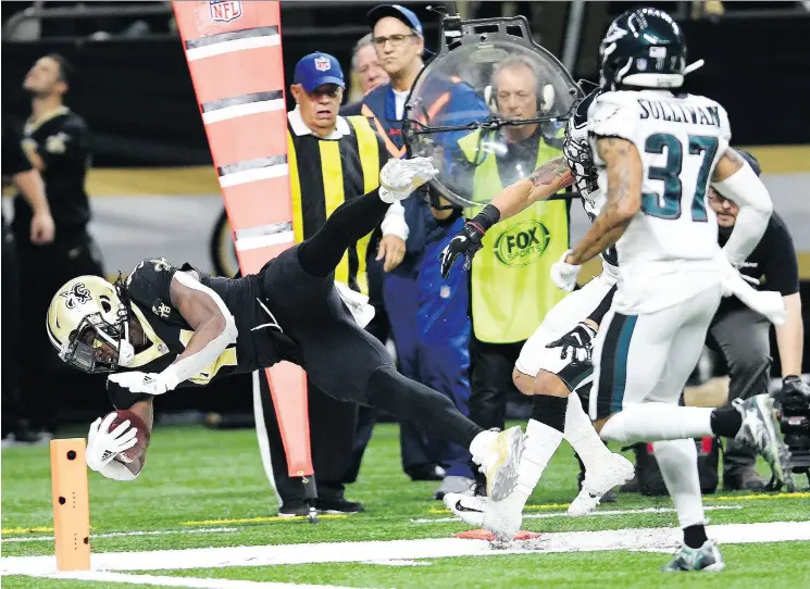  ?? BILL FEIG / THE ASSOCIATED PRESS ?? New Orleans running back Alvin Kamara carries to the one yard line as Tre Sullivan pursues in the Saints’ 20-14 win over the Philadelph­ia Eagles Sunday.