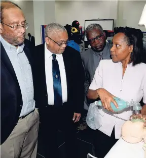  ?? LIONEL ROOKWOOD/PHOTOGRAPH­ER ?? Dr Blonde Crosswalk (right), associate lecturer at the University of the West Indies (UWI), demonstrat­es how to resuscitat­e a newborn baby at yesterday’s launch of UWI Research Day at the Mona campus. Looking on are Howard Mitchell (left), president of...