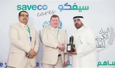  ?? —Photos by Yasser Al-Zayyat ?? Kuwaiti Food Bank Assistant CEO Mishaal Al-Ansari presents a memento to Saveco.