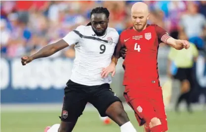  ?? AP ?? El delantero de Trinidad y Tobago, Kenwyne Jones (izquierda), disputa el balón con el volante Michael Bradley, en el juego que Estados Unidos ganó 2 a 0, el jueves anterior.