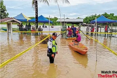  ?? ?? Not deterred: voters braving floodwater­s to cast their ballots at SK Telahak in Limbang, Sarawak . — Picture provided by
bomba