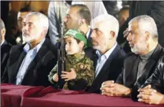  ?? MAHMUD HAMS/AFP ?? Yahya Sinwar (second from right), the new leader of the Hamas Islamist movement in the Gaza Strip and senior political leader Ismail Haniya (left) sit next to the son of Mazen Faqha, a Hamas leader who was shot dead by unknown gunmen in the Gaza Strip,...