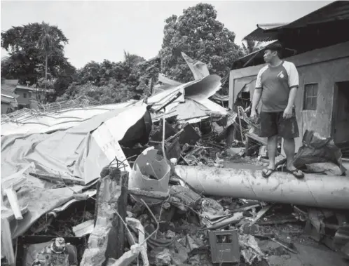  ?? (AFP) ?? BULACAN— A man looks on at debris of damaged houses after a water tank exploded in Bulacan, east of Manila on October 6, 2017. A 13-meter water tank containing at least 2,000 cubic meters of water burst that washed 60 houses killing 3 and wounding 44...