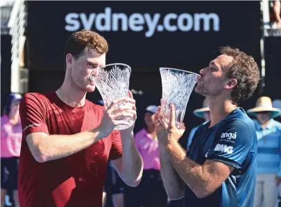  ?? PETER PARKS/AFP ?? Britânico Jamie Murray e brasileiro Bruno Soares beijam os troféus de campeões do Torneio de Sydney
