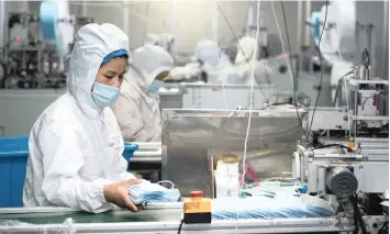  ??  ?? WORKERS make protective masks at the workshop of a company in Jinxian County, east of China’s Jiangxi Province, to help fight the coronaviru­s outbreak. | XINHUA/WAN XIANG/IANS