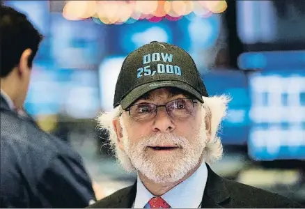  ?? LUCAS JACKSON / REUTERS ?? Un broker de Wall Street con la gorra de los 25.000 puntos, que se alcanzaron ayer