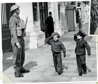  ??  ?? LEFT Making short work of the war – four-year old William Knowles, dressed as a private, and Billy Carter, dressed in an RAF uniform, salute the guardsman outside Buckingham Palace