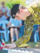  ?? Trooper Kallum Torpin from 2 Cav Regt lays a poppy in memory of his great uncle. ??