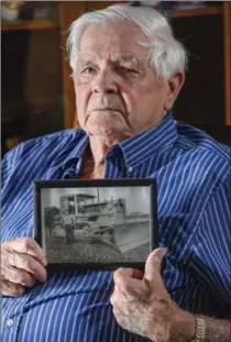  ?? GARY YOKOYAMA, THE HAMILTON SPECTATOR ?? Jim Kneller holds a photo of him as a young man operating heavy equipment in the 1950s.