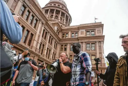  ?? Photos by Stephen Spillman / Contributo­r ?? Infowars founder Alex Jones moves Saturday through protesters at the Texas Capitol in Austin who were looking to end social and economic restrictio­ns aimed at slowing COVID-19.