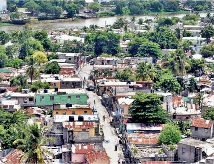  ??  ?? Los Guandules, ubicado en la ribera occidental del río Ozama, tiene una población de más de 30,000 habitantes, y sus jóvenes apuestan a un futuro más promisorio a través de la educación.