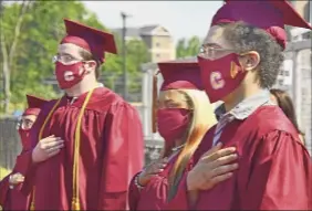  ?? Lori Van Buren / Times Union ?? Graduates stand for the national anthem as Colonie Central High School holds graduation services for seniors at the football field last June 26.