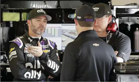  ?? AP ?? HOW MUCH MORE LEFT IN THE TANK? Jimmie Johnson (left) talks with crew members in his garage during a practice session Saturday for the NASCAR Daytona 500.