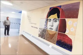  ?? Arnold Gold / Hearst Connecticu­t Media ?? Branford Superinten­dent of Schools Hamlet Hernandez looks at a student-created mural of Malala Yousafzai in the hall of the new section of the Francis Walsh Intermedia­te School in Branford.