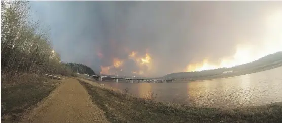  ?? ROBERT MURRAY/FORT MCMURRAY TODAY/FILES ?? Wildfires rage west of Fort McMurray last year, as viewed from the side of the Athabasca River.