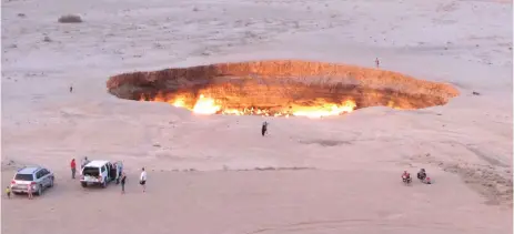  ?? — AFP file photos ?? People visit ‘The Gateway to Hell,’ a huge burning gas crater in the heart of Turkmenist­an’s Karakum desert on June 11, 2014.