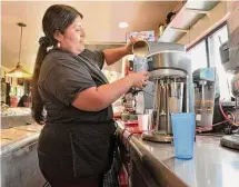  ?? ?? Waitress Jessica Yunganaula, of Danbury, pours a milkshake into a glass at the Sycamore Drive-In Restaurant on Wednesday.