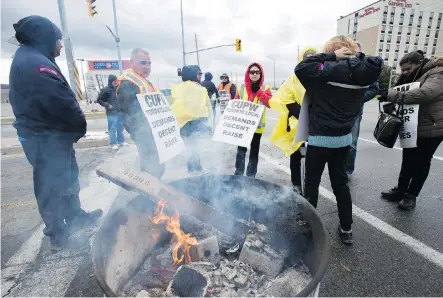  ?? FRANK GUNN/THE CANADIAN PRESS ?? Striking Canada Post workers walk the picket line in Mississaug­a, Ont., on Tuesday. Morton Mitchnick has been appointed to join a team of federal mediators in talks with Canada Post and the Canadian Union of Postal Workers over contract demands.