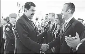  ??  ?? President Nicholas Maduro schudt zijn nieuwe vicepresid­ent Tareck El Aissami de hand. (Ad)