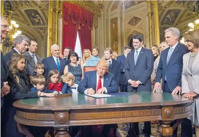  ?? EFE ?? Trump aparece rodeado de su familia y congresist­as cuando firmaba el nombramien­to de su gabinete.