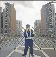  ?? (AP/Hiro Komae) ?? A guard stands in front of a fence to close off a constructi­on site for the athletes’ village to be used during the Tokyo 2020 Olympic and Paralympic Games in Tokyo.