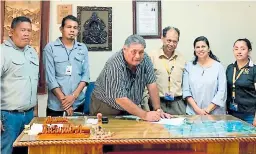  ??  ?? Ricardo Alvarado, alcalde de Omoa, firma la carta de oficio en presencia de los funcionari­os de la Unah.