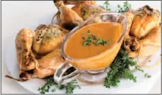  ?? The Associated Press ?? Herb-roasted Cornish game hens are served with a creamy mustard sauce made with evaporated skim milk.