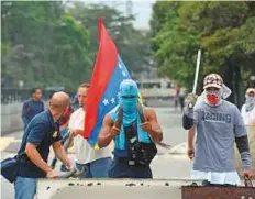  ?? AFP ?? Opposition activists set up a barricade to block an avenue in Caracas yesterday. Protesters set out to block Venezuela’s main roads including the capital’s biggest motorway.