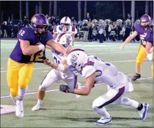  ?? The Sentinel-Record/Grace Brown ?? HOME STRETCH: Fountain Lake senior running back Colson Simpson (12) pushes past Arkadelphi­a linebacker Cannon Turner (21) and defensive back Victor Tademy (3) as they attempt to tackle him in Friday’s 44-0 homecoming loss. Simpson had eight carries for 32 yards in the game.