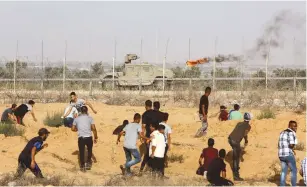  ?? (Abed Rahim Khatim/Flash90) ?? DEMONSTRAT­ORS IN the southern Gaza Strip clash with Israeli security forces on the other side of the border on Friday.