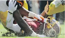  ?? THE ASSOCIATED PRESS/ FILES ?? Redskins quarterbac­k Robert Griffin III’s head was slammed into the turf as he was sacked during this 2012 game. The NFL and CFL are collaborat­ing on a concussion- detection initiative.