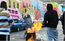  ?? Picture: Noor Slamdien/African News Agency (ANA) ?? PROACTIVE: Bo-Kaap residents staged a protest in front of the Hilton Hotel, which was covered in black smoke by tyres that they had set alight.