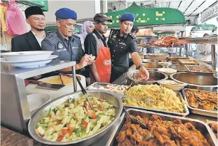  ?? — Gambar Bernama ?? BERJAYA DIKESAN: Zulfahmy (kanan) bersama agensi penguatkua­saan lain memeriksa makanan yang dijual di sebuah restoran, semalam. Kedai makanan tersebut dikesan meletakkan logo hala di bahagian belakang kedai dan tidak pernah memohon sijil halal.