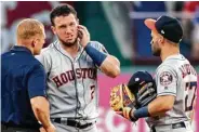  ?? Jeffrey McWhorter / Associated Press ?? Alex Bregman, center, attracts attention after taking a bad-hop ground ball to the face in the third inning.