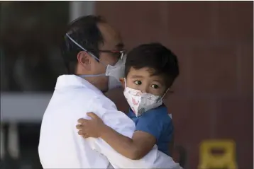  ?? JAE C. HONG — THE ASSOCIATED PRESS FILE PHOTO ?? Callum Diaz-Cheng, 3, clings to his father, Dr. Andrew Cheng, before receiving the Pfizer COVID-19vaccine at Children's Hospital Los Angeles in Los Angeles in 2022.