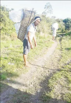  ?? (Photo courtesy Edward McGarrell) ?? Toshao of Chenapau Village, Edward McGarrell transporti­ng emergency supplies to residents using the traditiona­l Indigenous Warishi.