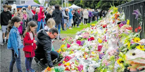  ?? DPA-BILD: THIAN ?? Trauernde Menschen legen am Sonntag im neuseeländ­ischen Christchur­ch Blumen nieder.