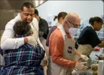  ?? Pittsburgh Post-Gazette ?? Mattie Hardine, of East Liberty, a member of the Urban League of Greater Pittsburgh, receives a hug from Mayor Ed Gainey while serving Thanksgivi­ng meals Friday at the East End Cooperativ­e Ministry in East Liberty.